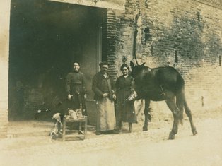 Le maréchal-ferrant Miquel et sa famille devant la maison, 1910 Photo d'un groupe de personne devant un commerce