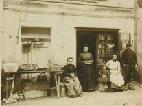 Épicerie Ressilié 1902, sur cette photo, de gauche à droite : Célestine Bécaïs, Anna Ressilié, Anna Baldi et la petite fille Jeanne Gleize et Astor. À remarquer la boîte de biscuits Emile Poult Photo d'une épicerie